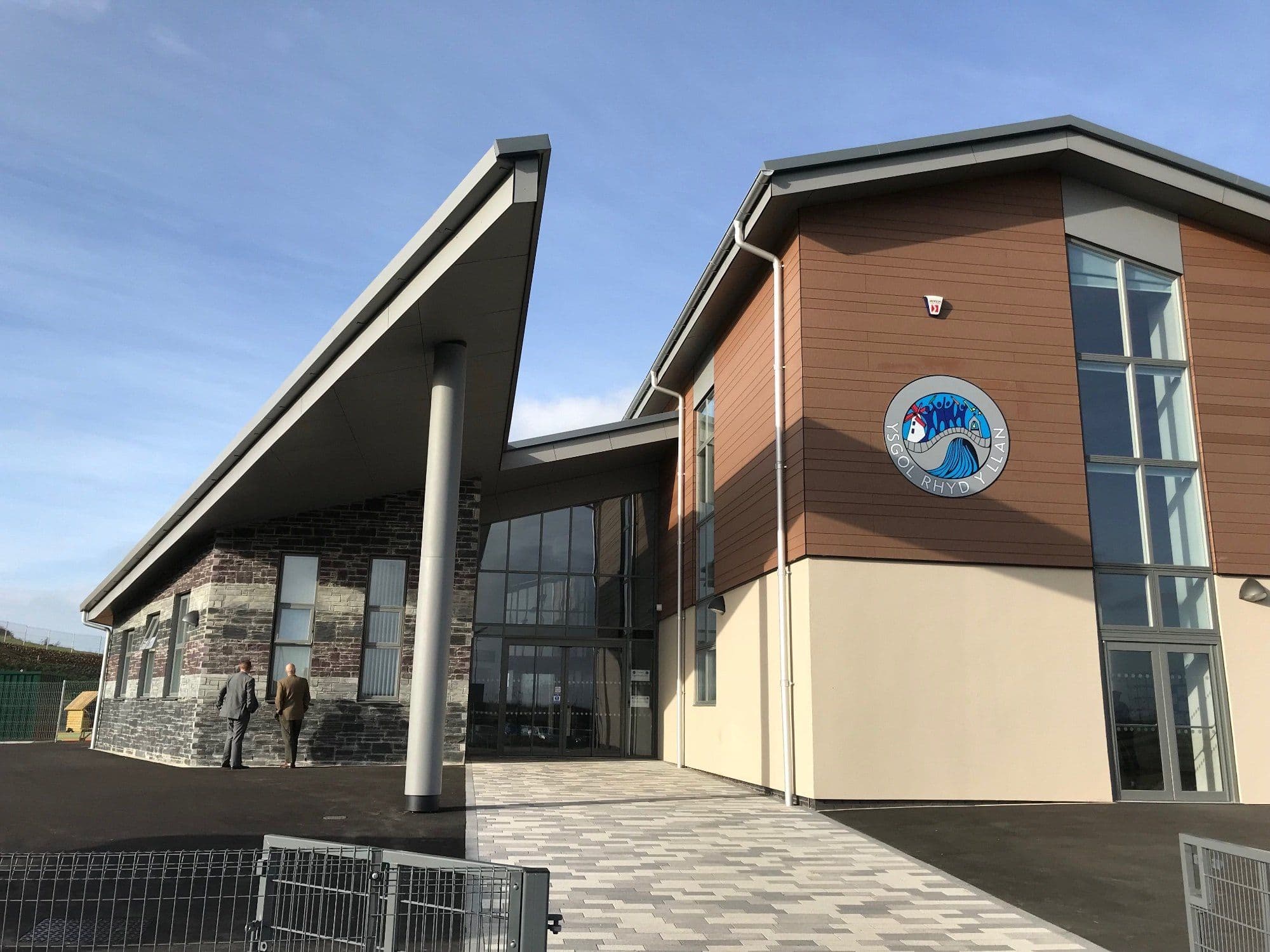 Main entrance of a completed school building with a curved canopy