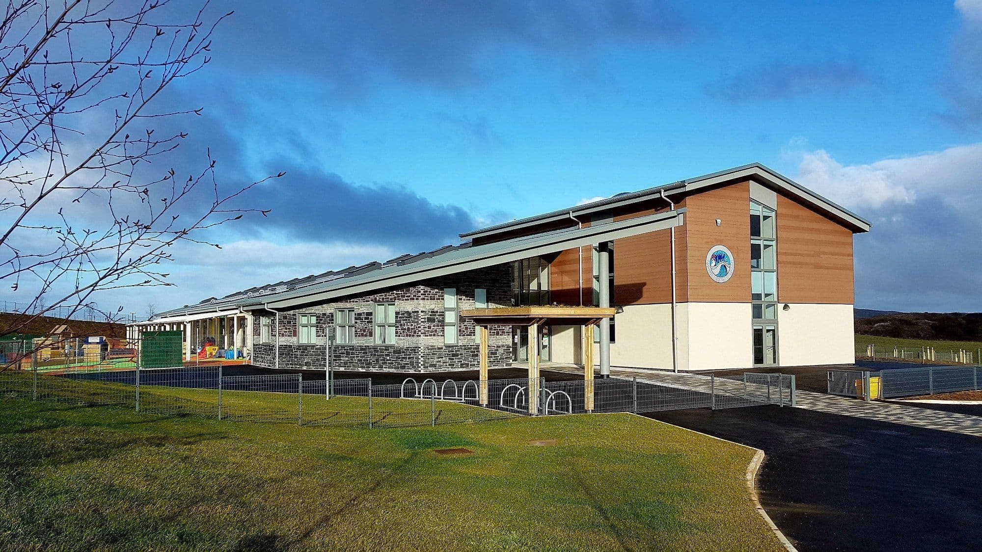 Completed school building with timber and stone cladding